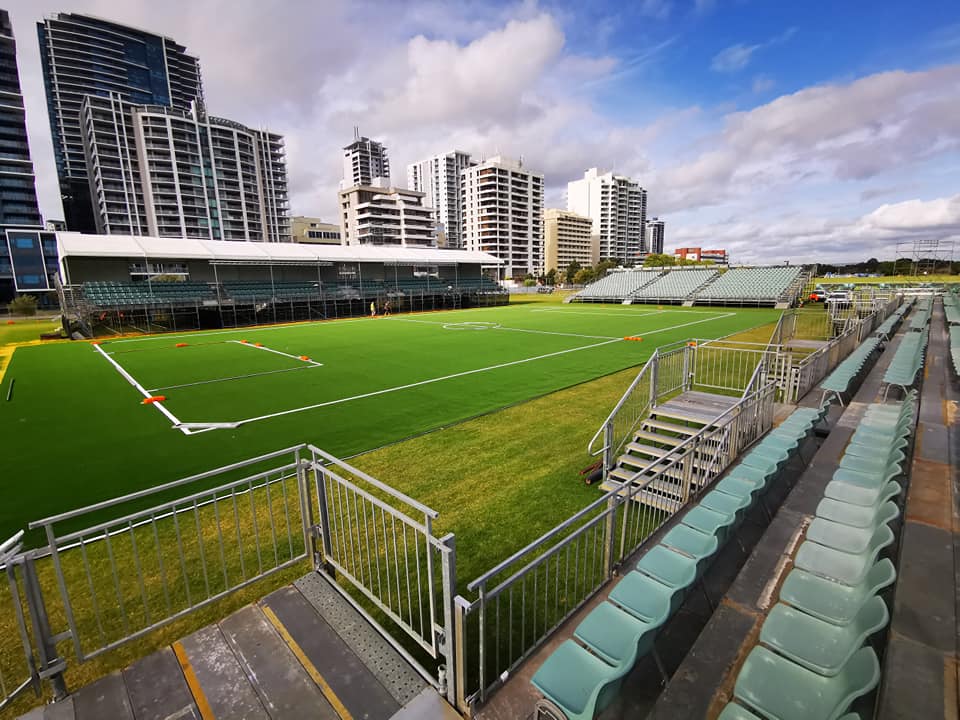 Synthetic turf sporting field with grandstand seating